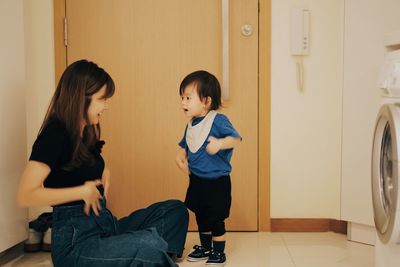 Smiling mother gesturing son at home