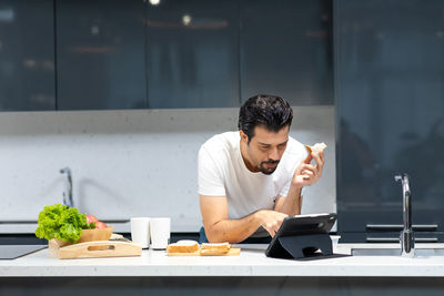 Young man using laptop in restaurant