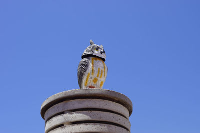 Low angle view of bird against clear blue sky