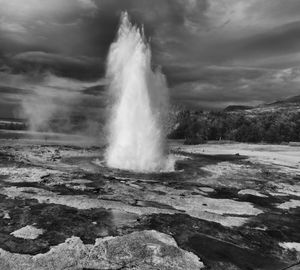 Eruption of strokkur geyser against clouds