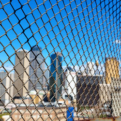 Close-up of chainlink fence against blue sky