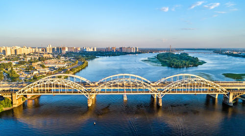 Bridge over river in city against sky