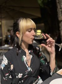 Portrait of young woman drinking water