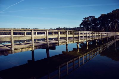 Bridge over river against clear blue sky