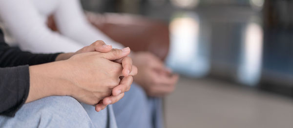 Midsection of couple holding hands