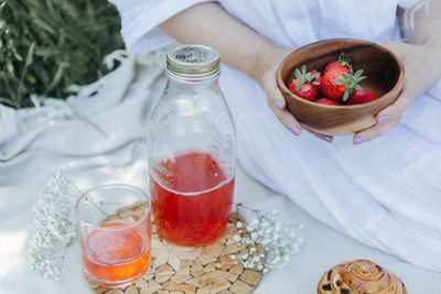 Picnic scene girl holding bowl of strawberries