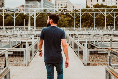 Rear view of man standing against buildings in city