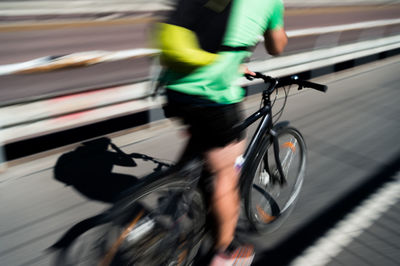 Low section of man riding bicycle in city