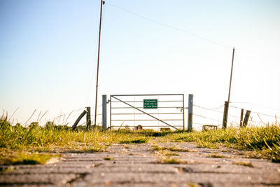 Surface level of empty footpath against clear sky