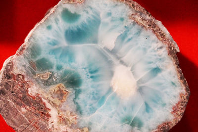 Close-up of crystal ball on rock against colored background