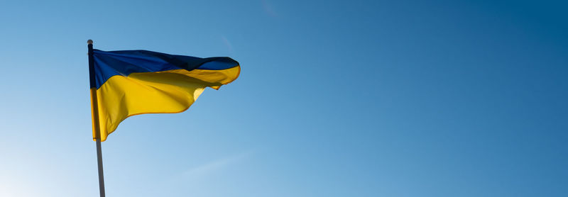 Flag of ukraine on blue sky background. national symbol of freedom and independence. slava ukraini 