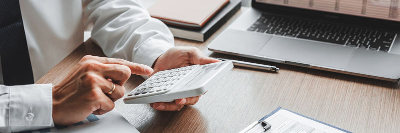 Midsection of man using laptop on table