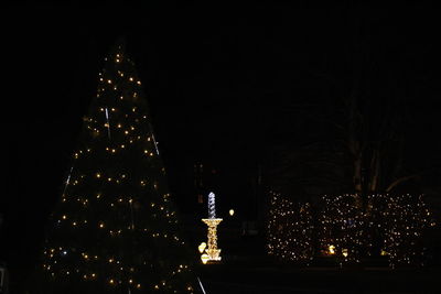 Low angle view of illuminated christmas tree against sky at night
