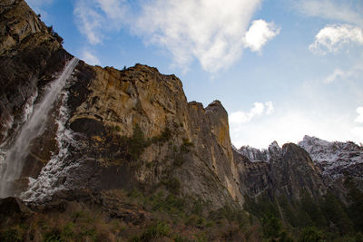 Low angle view of rocky mountains against sky