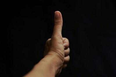 Cropped image of hand over black background