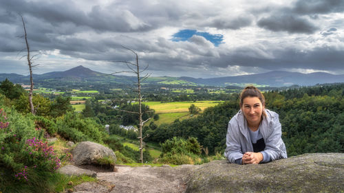 Portrait of man standing on mountain against cloudy sky