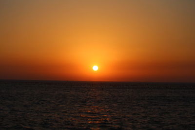 Scenic view of sea against dramatic sky during sunset