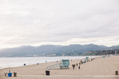 Scenic view of beach against cloudy sky