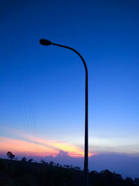 Low angle view of street light against blue sky