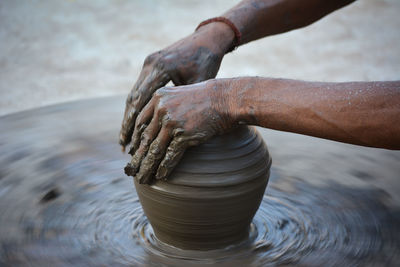 Midsection of man working in mud