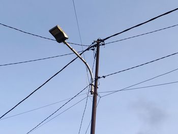 Low angle view of electricity pylon against clear sky