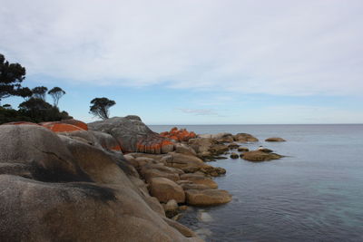 Rock formations by sea against sky