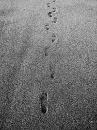 Close-up of footprints on sand at beach