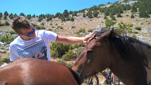 Young woman with horse standing on mountain