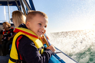 Cute smiling boy sitting on boat