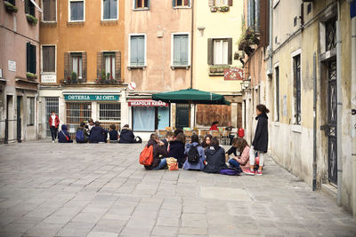 People walking on street amidst buildings in city