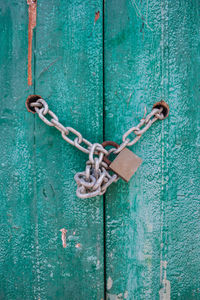 Close-up of padlock in chain hanging on door