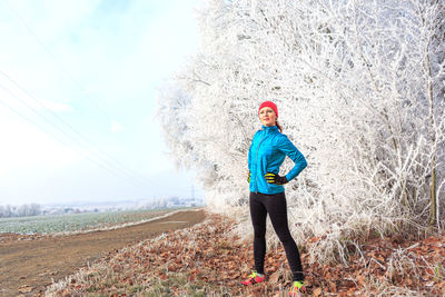 Woman standing against tree during winter
