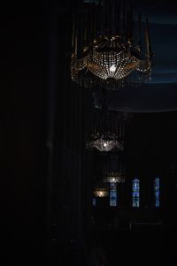 Illuminated chandelier hanging against black background