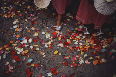 Low section of woman standing by autumn leaves