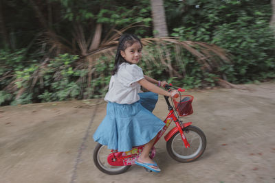 Full length of woman riding bicycle