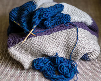 Picture with knitted sweater, knitting needles and yarn, close-up view