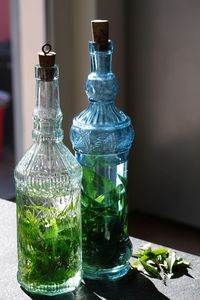 Close-up of drink with herbs in bottles on table