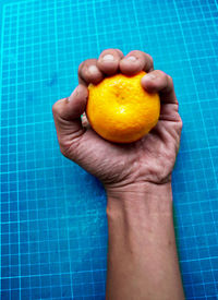 Close-up of hand holding orange