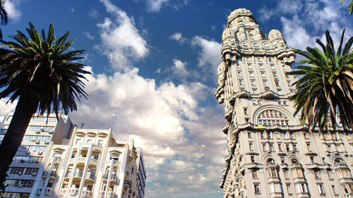 Low angle view of palm trees and buildings