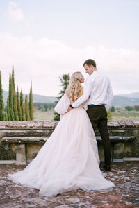 Rear view of couple standing against sky