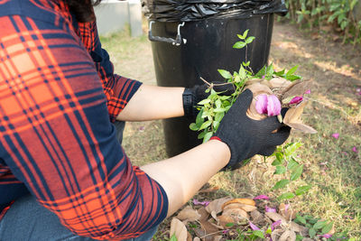 Midsection of woman holding flowering plants