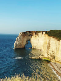 Scenic view of sea against clear blue sky etretat cliff beach france sunset blue water clear sky sun 