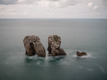 Rocks in sea against sky