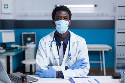 Portrait of doctor wearing mask sitting at clinic