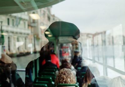 Reflection of woman photographing on glass