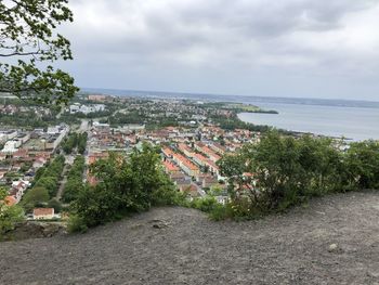 Aerial view of town by sea against sky