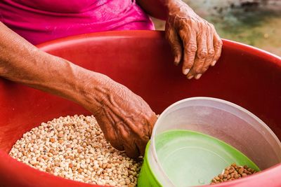 Midsection of woman cleaning food in container