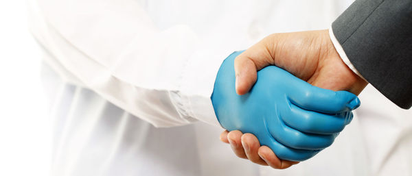 Midsection of doctor holding dentures