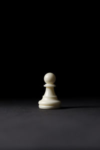 Isolated white pawn chess piece on black background