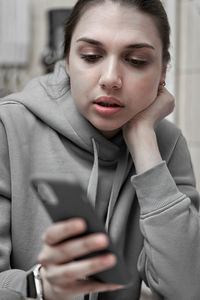 Midsection of young woman using mobile phone